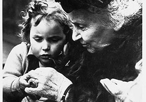 Maria Montessori z dziewczynka, oglądają muszelki.
